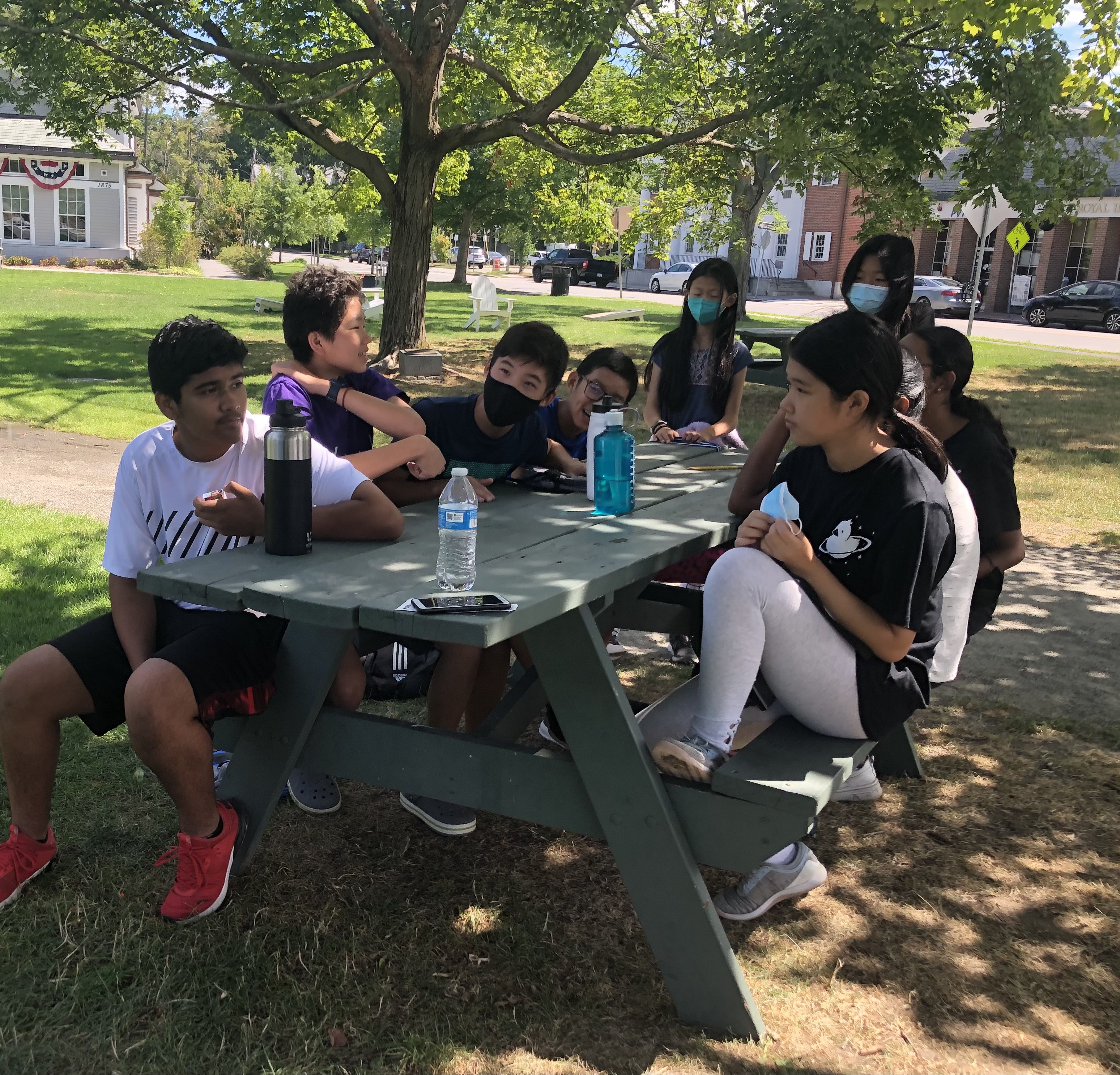 Students sitting on at a table, watching a teacher of Science Outdoors in 2021